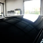Experience professional car detailing Chattanooga with a shining black sedan and organized tools.